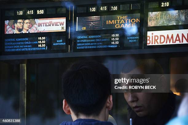 Movie-goer speaks with the ticket seller at the Los Feliz 3 cinema in Los Angeles, California where "The Interview" opened on December 25, 2014. Some...