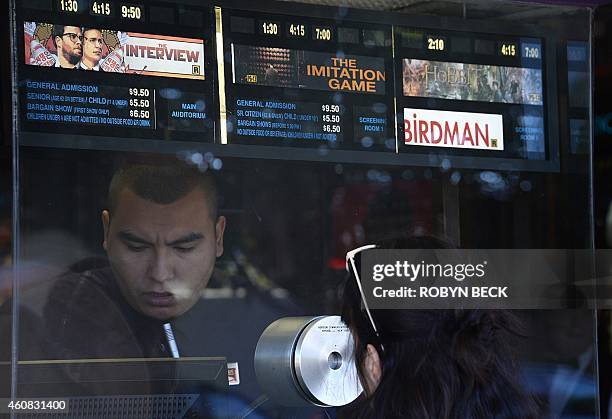 Movie-goer speaks with the ticket seller at the Los Feliz 3 cinema in Los Angeles, California where "The Interview" opened on December 25, 2014. Some...