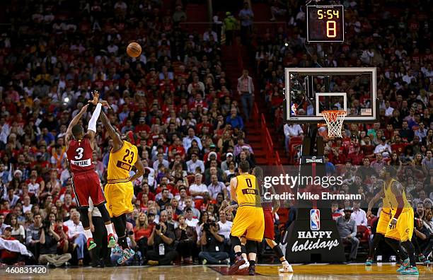 Dwyane Wade of the Miami Heat shoots over LeBron James of the Cleveland Cavaliers during a game at American Airlines Arena on December 25, 2014 in...