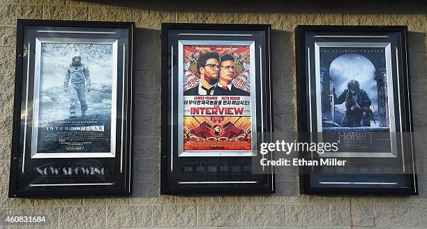 Movie posters, including one for "The Interview," are displayed outside the Megaplex Theatres - Stadium 6 as the Sony Pictures' film opens on...