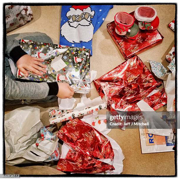 Boy opens Christmas presents on December 25, 2014 in Glasgow, Scotland. Millions of people across the UK spend time with family and loved ones on...