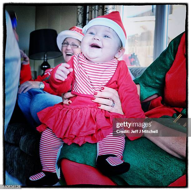 Young child laugh while wearing a Santa hat on December 25, 2014 in Glasgow, Scotland. Millions of people across the UK spend time with family and...