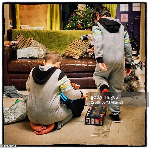 Two boys open Christmas peasants on December 25, 2014 in Glasgow, Scotland. Millions of people across the UK spend time with family and loved ones on...