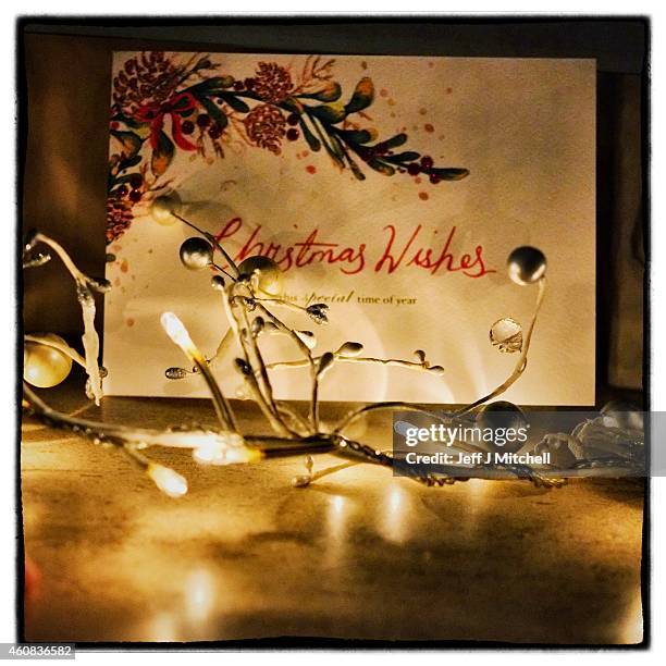 Christmas lights and a card is placed on a mantel piece on December 25, 2014 in Glasgow, Scotland. Millions of people across the UK spend time with...