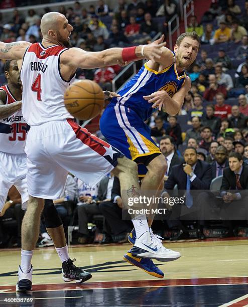 Golden State Warriors power forward David Lee passes the ball around Washington Wizards center Marcin Gortat during the first half of their game...