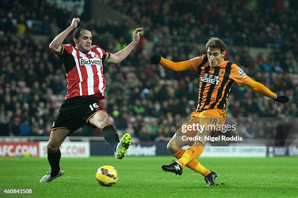 Nikica Jelevic of Hull City scores his team's third goal despite the efforts of John O'Shea of Sunderland during the Barclays Premier League match...
