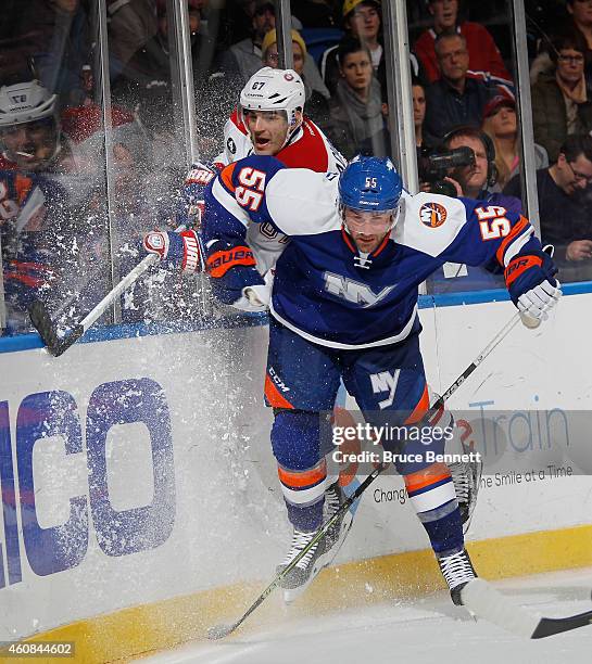 Max Pacioretty of the Montreal Canadiens is checked into the boards by Johnny Boychuk of the New York Islanders at the Nassau Veterans Memorial...