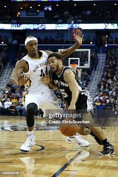 Cory Joseph of the San Antonio Spurs drives the ball around Dante Cunningham of the New Orleans Pelicans at Smoothie King Center on December 26, 2014...