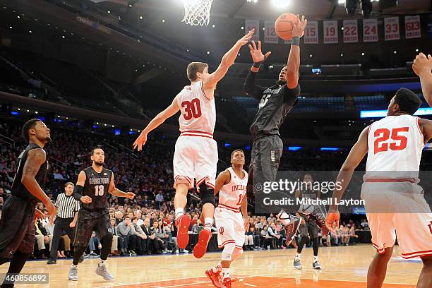 Jabril Trawick of the Georgetown Hoyas takes a shot over Collin Hartman of the Indiana Hoosiers during a college basketball game at Madison Square...