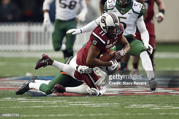 Pharoh Cooper of the South Carolina Gamecocks is brought down by Corn Elder of the Miami Hurricanes during the second quarter of the Duck Commander...