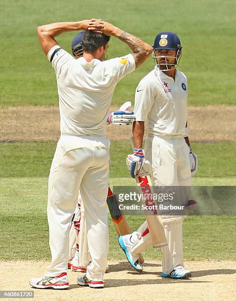 Virat Kohli of India and bowler Mitchell Johnson of Australia exchange words at the end of an over after Kohli was struck by a throw at the stumps...