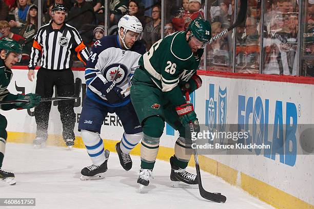 Thomas Vanek of the Minnesota Wild handles the puck with Grant Clitsome of the Winnipeg Jets defending during the game on December 27, 2014 at the...