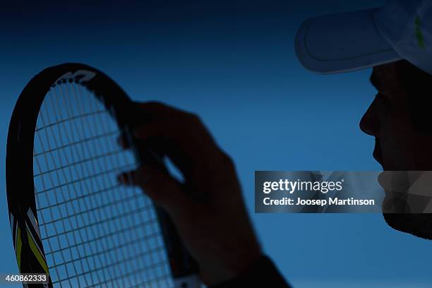 Blaz Kavcic of Slovenia plays adjusts his racquet strings in his qualifying match against Albert Ramos of Spain during day two of the Sydney...