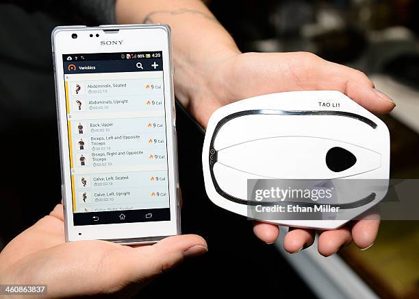 The Tao Wellness WellShell is pictured with a phone displaying information from the device at a press event at the Mandalay Bay Convention Center for...