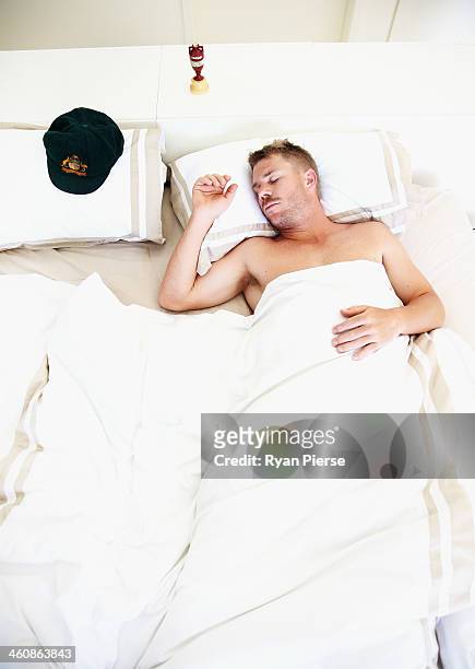 Australian Cricketer David Warner sleeps next to his Baggy Green Cap and a replica Ashes Urn at his home on January 6, 2014 in Sydney, Australia....