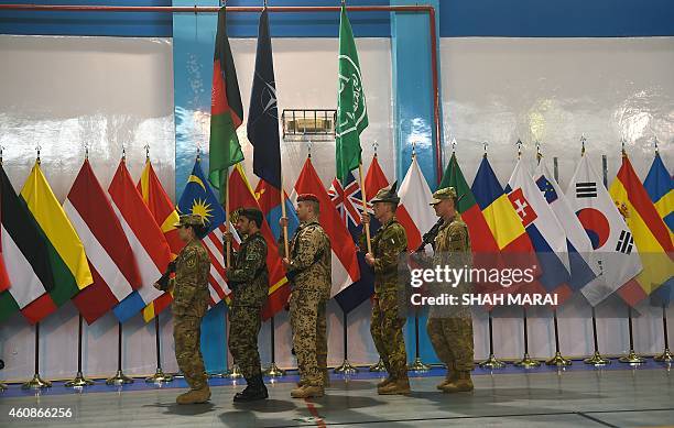 Led International Security Assistance Force soldiers carry flags during a ceremony marking the end of ISAF's combat mission in Afghanistan at ISAF...