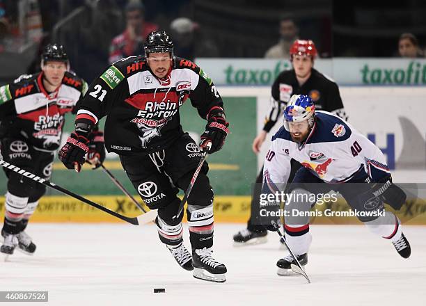 John Tripp of Koelner Haie is chased by Daniel Sparre of EHC Red Bull Muenchen during the DEL Ice Hockey game between Koelner Haie and EHC Red Bull...