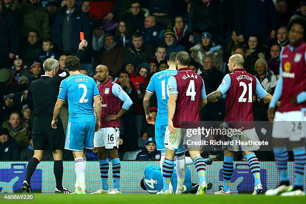 Fabian Delph of Aston Villa receives a red card from referee Martin Atkinson during the Barclays Premier League match between Aston Villa and...