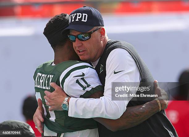 Head coach Rex Ryan of the New York Jets wears a NYPD hat as he greets wide receiver Jeremy Kerley during pregame workouts before the Jets met the...