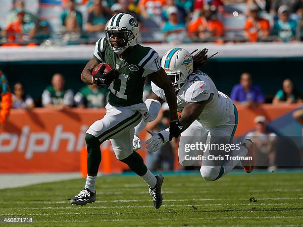 Wide receiver Jeremy Kerley of the New York Jets picks up yardage as middle linebacker Kelvin Sheppard of the Miami Dolphins pursues during a game at...