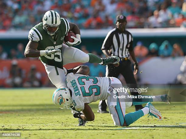 Outside linebacker Jelani Jenkins of the Miami Dolphins brings down tight end Jeff Cumberland of the New York Jets in the third quarter during a game...