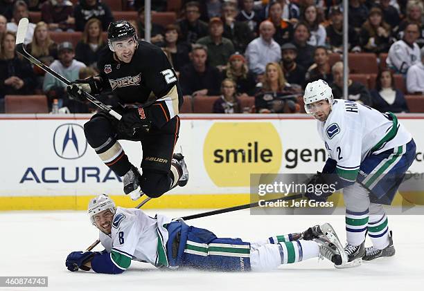 Kyle Palmieri of the Anaheim Ducks jumps to avoid Chris Tanev of the Vancouver Canucks, as Dan Hamhuis of the Canucks pursues the play in the third...