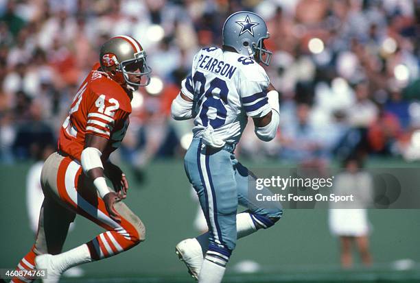 Wide Receiver Drew Pearson of the Dallas Cowboys runs with the ball, pursued by Ronnie Lott of the San Francisco 49ers during an NFL football October...