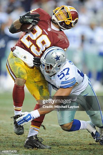 Middle linebacker DeVonte Holloman of the Dallas Cowboys puts a hit running back Roy Helu of the Washington Redskins running with the ball in the...