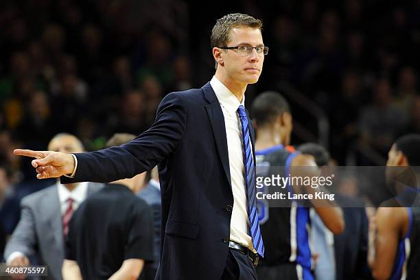 Special Assistant Jon Scheyer of the Duke Blue Devils points toward an inbounds spot during a stop in play against the Notre Dame Fighting Irish at...