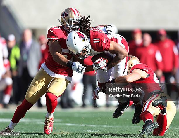 Larry Fitzgerald of the Arizona Cardinals is stopped by Michael Wilhoite of the San Francisco 49ers and Craig Dahl of the San Francisco 49ers in the...