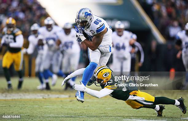 Eric Ebron of the Detroit Lions tries to avoid the tackle of Micah Hyde of the Green Bay Packers in the first quarter at Lambeau Field on December...