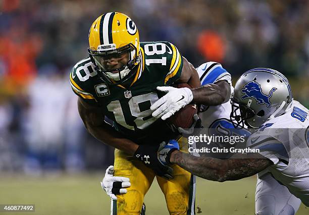 Randall Cobb of the Green Bay Packers runs for a first down against the defense of Cassius Vaughn and Glover Quin of the Detroit Lions in the second...