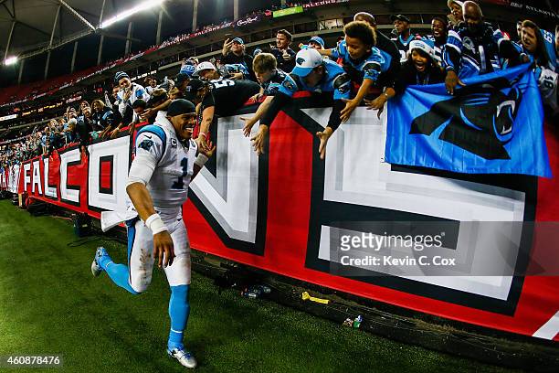 Cam Newton of the Carolina Panthers celebrates with fans after beating the Atlanta Falcons at the Georgia Dome on December 28, 2014 in Atlanta,...