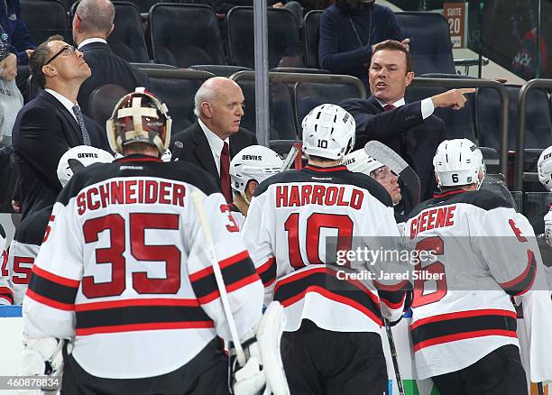 Interim coach Lou Lamoriello and co-coaches Adam Oates and Scott Stevens of the New Jersey Devils talk to their players during a timeout in the third...