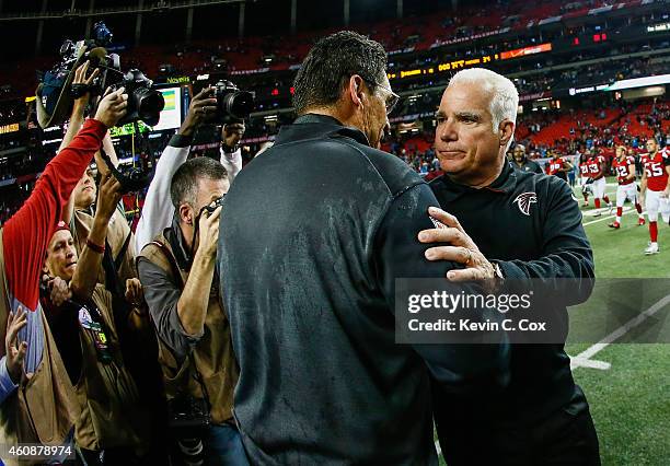 Head coach Mike Smith of the Atlanta Falcons shakes hands with head coach Ron Rivera of the Carolina Panthers after the game at the Georgia Dome on...