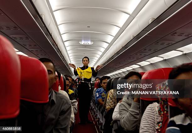 An AirAsia flight attendant gives a safety demonstration while onboard a flight preparing to depart from Kuala Lumpur to Surabaya at Kuala Lumpur...