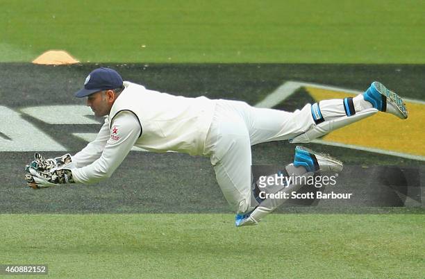 Dhoni of India dives to take a catch to dismiss Joe Burns of Australia during day four of the Third Test match between Australia and India at...