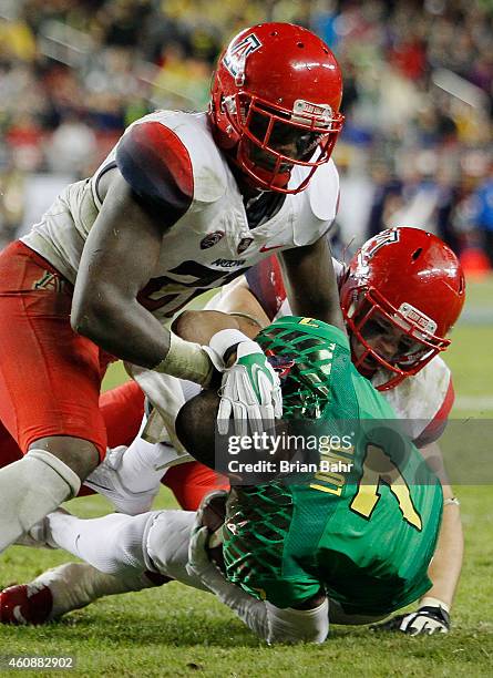 Wide receiver Keanon Lowe of the Oregon Ducks rushes for nine yards to the Arizona Wildcats four yard line as he loses his helmet and protects his...