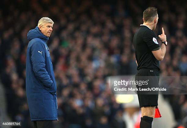 Arsenal manager Arsene Wenger in discussion with an assistant referee during the Barclays Premier League match between West Ham United and Arsenal at...