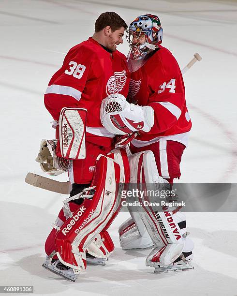 Tom McCollum of the Detroit Red Wings congratulates teammate Petr Mrazek after a NHL game against the Buffalo Sabres on December 23, 2014 at Joe...