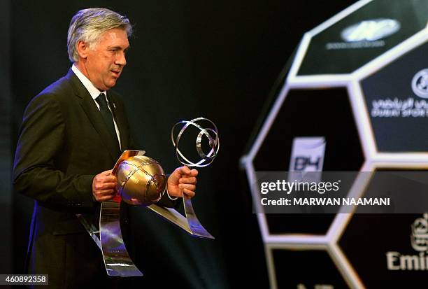 Real Madrid football club's manager Carlo Ancelotti walks holding his "Best Media Attraction of the Year" and "Best Coach" awards during the Globe...