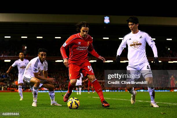 Lazar Markovic of Liverpool runs with the ball in between Neil Taylor and Ki Sung-Yueng of Swansea City during the Barclays Premier League match...