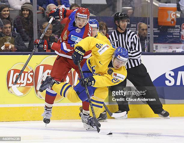 Vladislav Kamenev of Team Russia skates to check Leon Bristedt of Team Sweden in a 2015 IIHF World Junior Championship game at the Air Canada Centre...