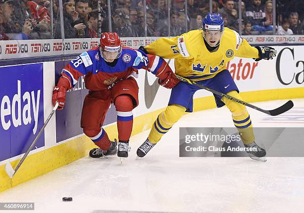 Segei Tolchinski of Team Russia battles for a puck against Robert Hagg of Team Sweden in a 2015 IIHF World Junior Championship game at the Air Canada...