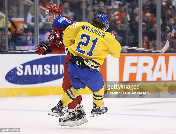 Vladislav Kamenev of Team Russia lays a big hit on William Nylander of Team Sweden in a 2015 IIHF World Junior Championship game at the Air Canada...