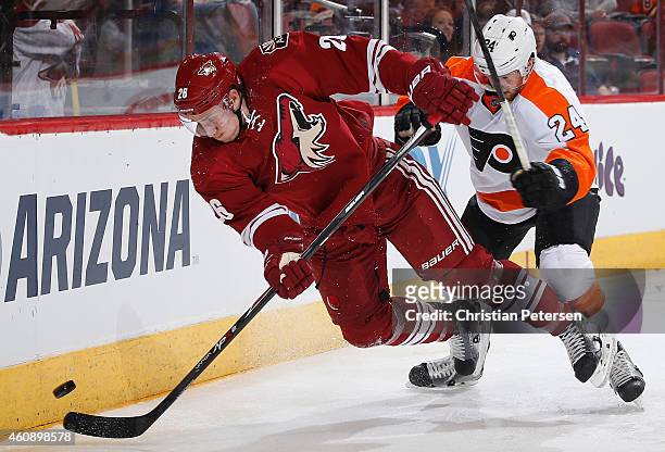 Michael Stone of the Arizona Coyotes is checked off the puck from Matt Read of the Philadelphia Flyers during the second period of the NHL game at...