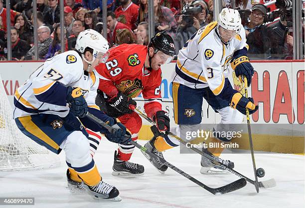 Bryan Bickell of the Chicago Blackhawks chases the puck against Gabriel Bourque and Seth Jones of the Nashville Predators during the NHL game at the...