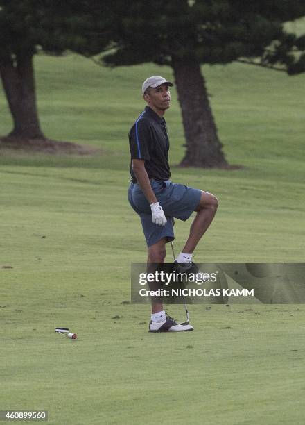 President Barack Obama reacts to his shot onto the 18th green as he plays golf at the Mid-Pacific Country Club in Kailua on December 29, 2014 . AFP...