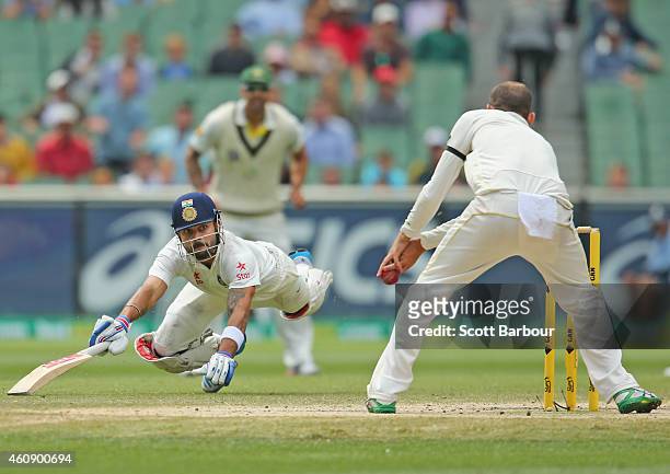 Virat Kohli of India dives to make his ground as Nathan Lyon of Australia misses a run out opportunity during day five of the Third Test match...