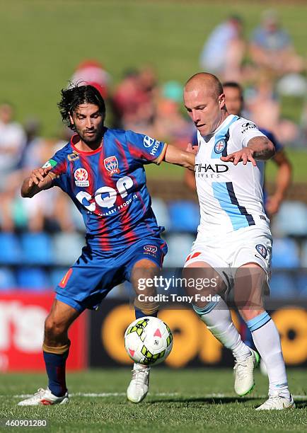 Zenon Caravella of the Jets contests the ball with Aaron Mooy of Melbourne City during the round 14 A-League match between the Newcastle Jets and...